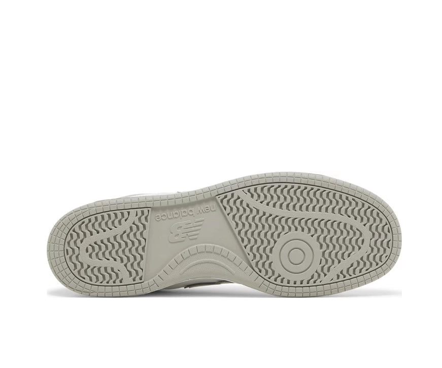 A white leather New Balance basketball shoe with gray accents.