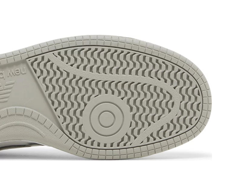A white leather New Balance basketball shoe with gray accents.