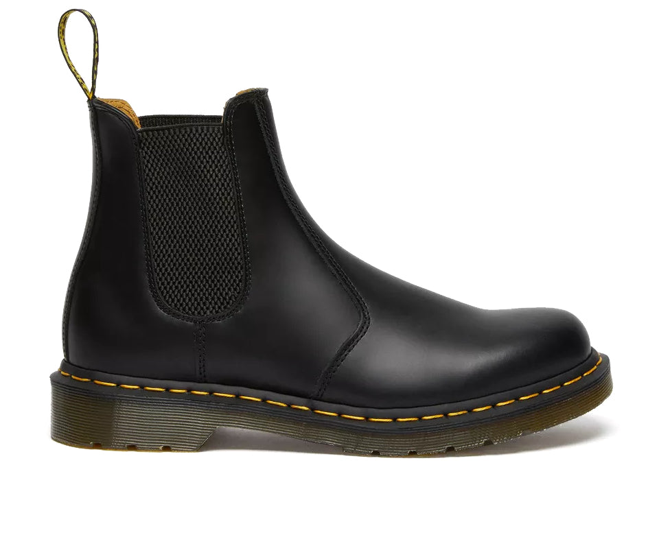 Side profile of a mid-ankle Dr. Martens black leather chelsea boot.