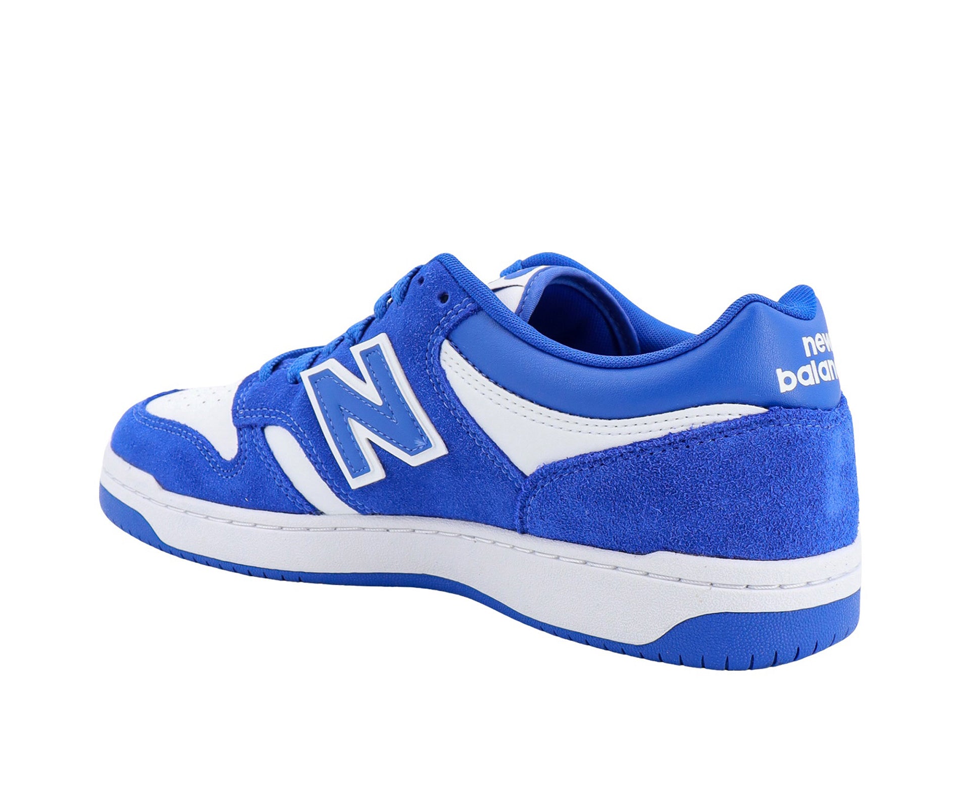 A white leather New Balance basketball shoe with royal blue suede accents.