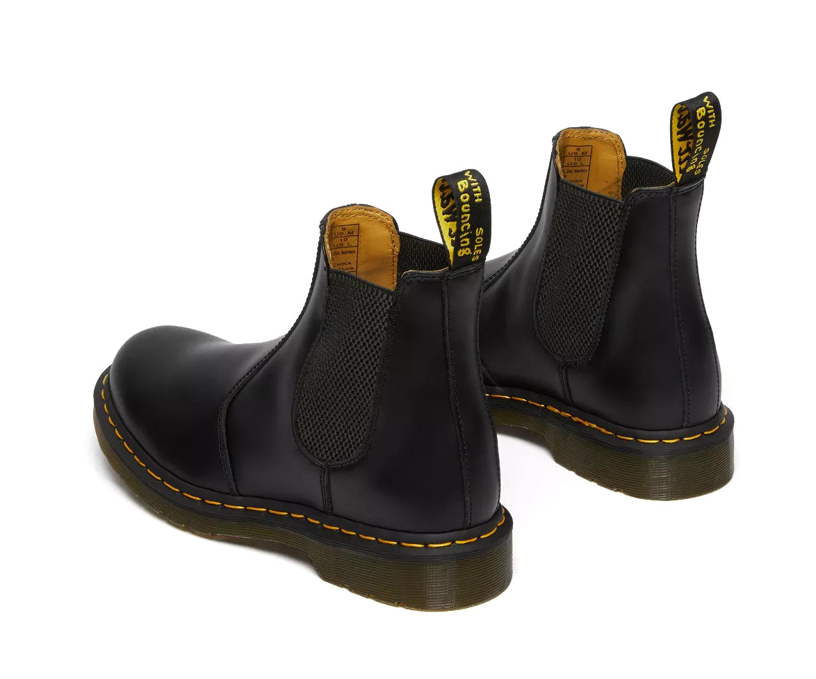 A pair of mid-ankle Dr. Martens black leather chelsea boots.