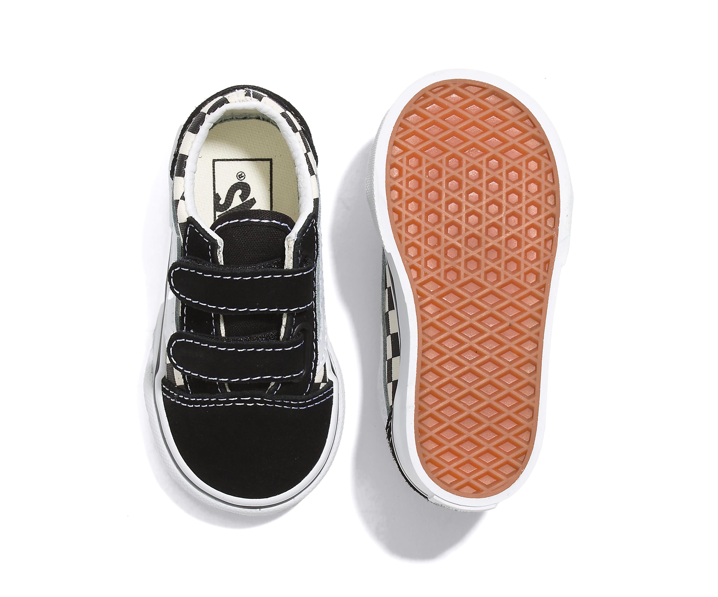 A checkerboard black and white canvas and suede kids' sneaker with velcro straps.