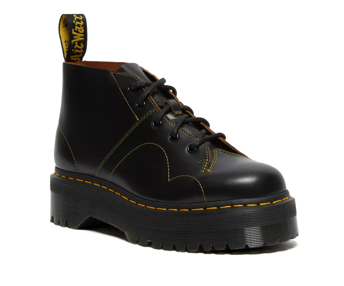 A black leather platform chukka boot with yellow stitch accents from Dr. Martens.