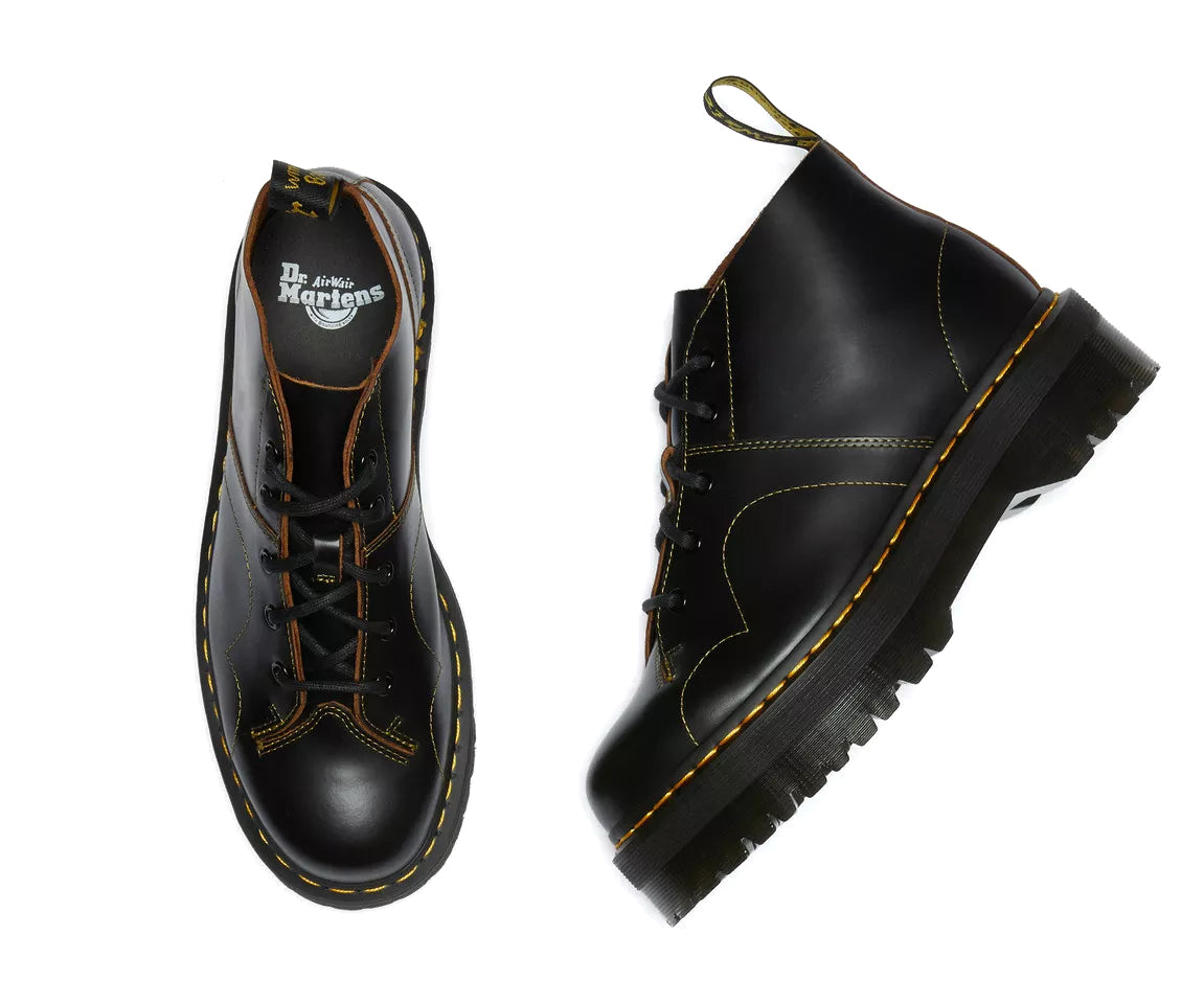 A black leather platform chukka boot with yellow stitch accents from Dr. Martens.