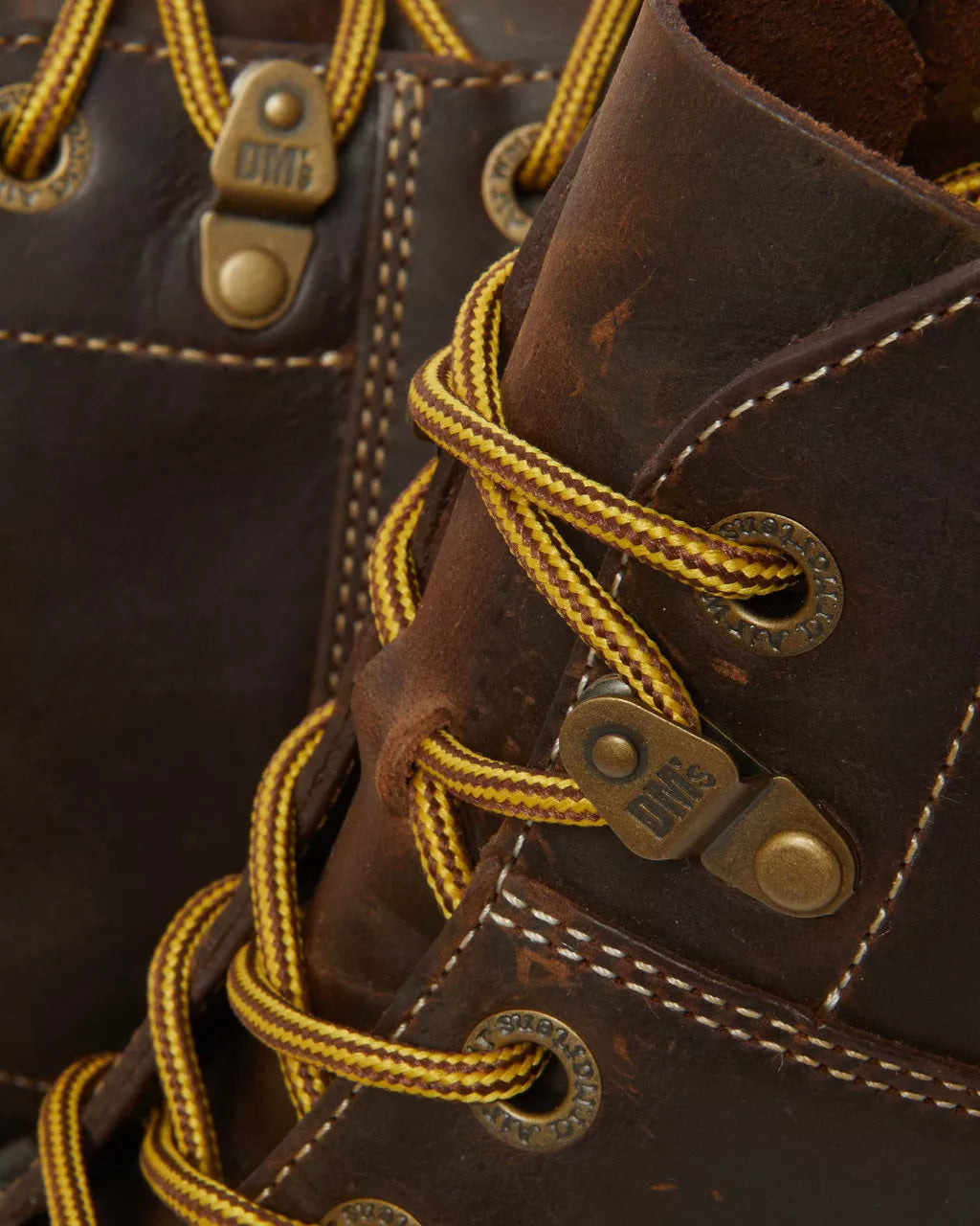 A dark brown leather chukka boot with yellow stitch accents from Dr. Martens.