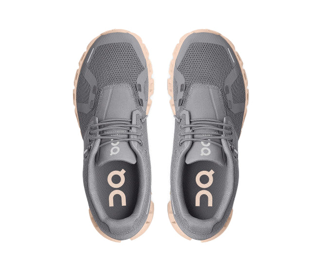 A grey running shoe with peach sole from On Running.