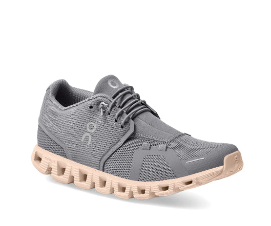 A grey running shoe with peach sole from On Running.