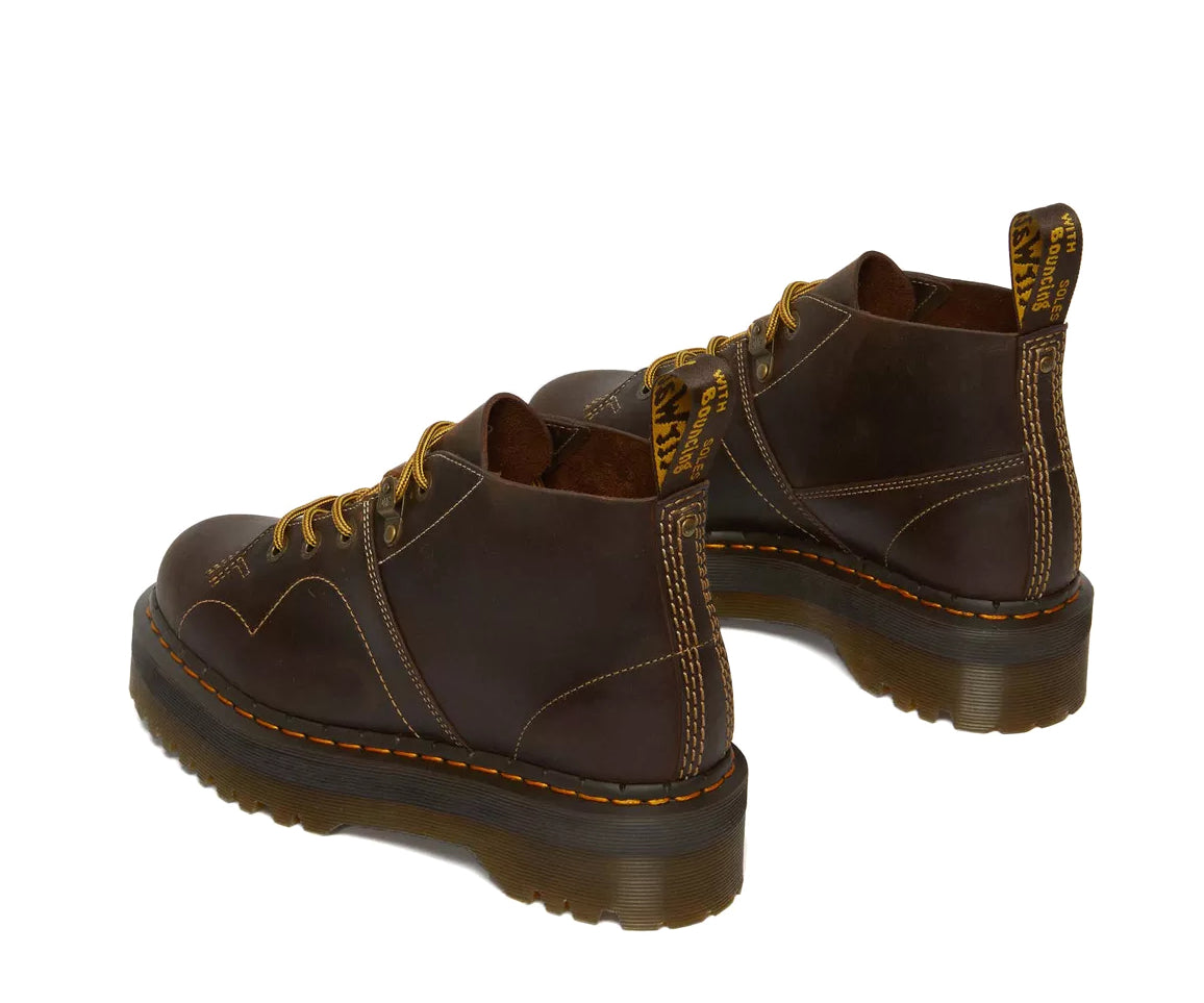 A dark brown leather chukka boot with yellow stitch accents from Dr. Martens.