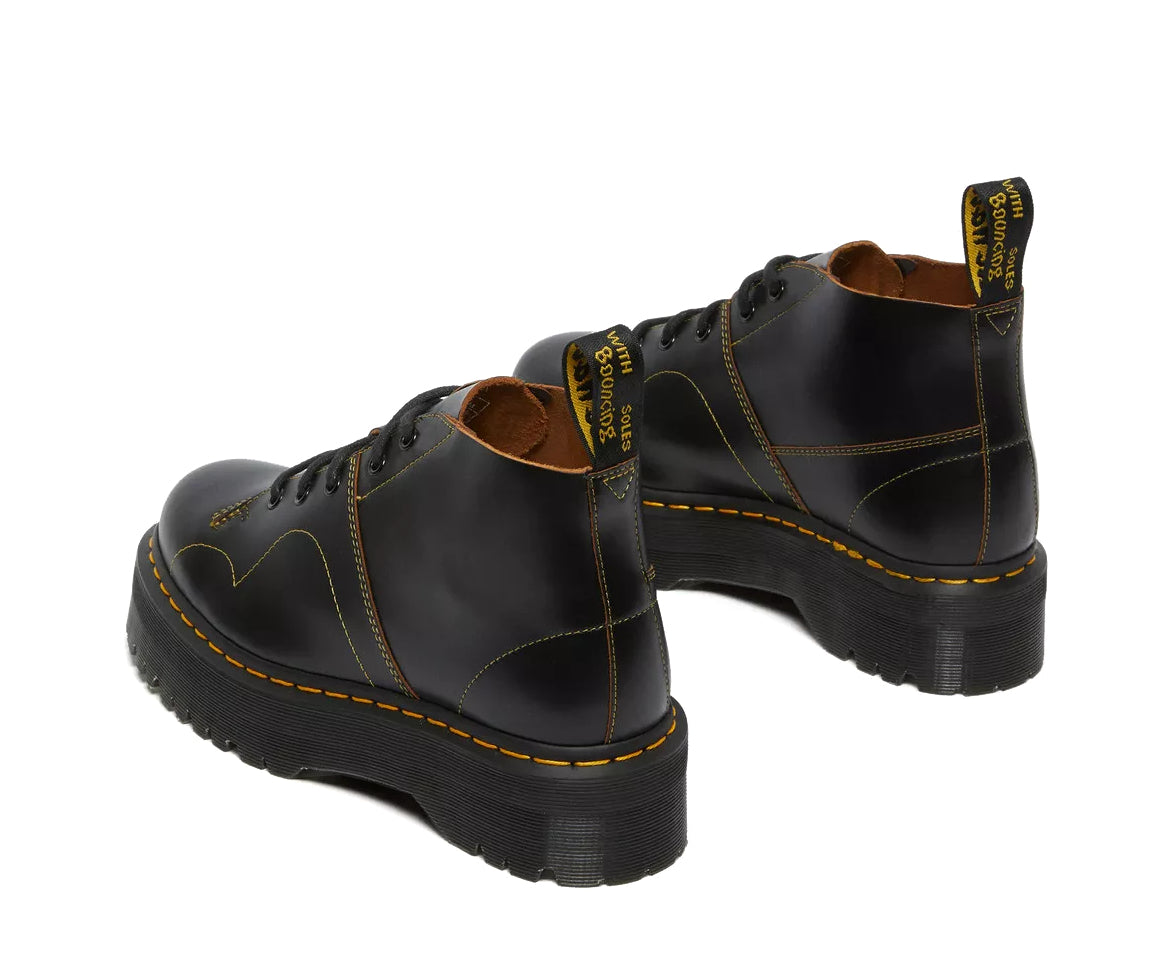 A black leather platform chukka boot with yellow stitch accents from Dr. Martens.