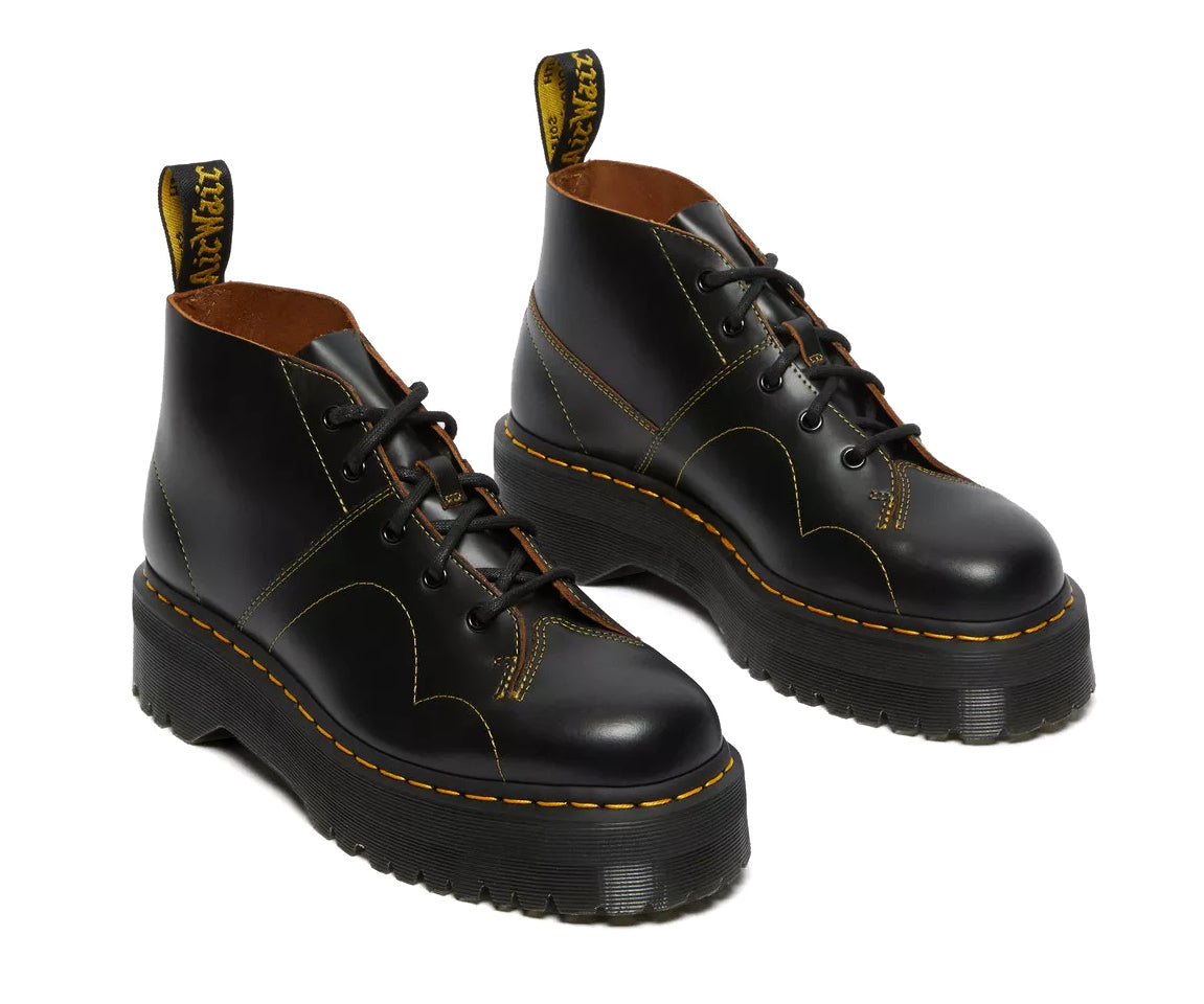 A black leather platform chukka boot with yellow stitch accents from Dr. Martens.