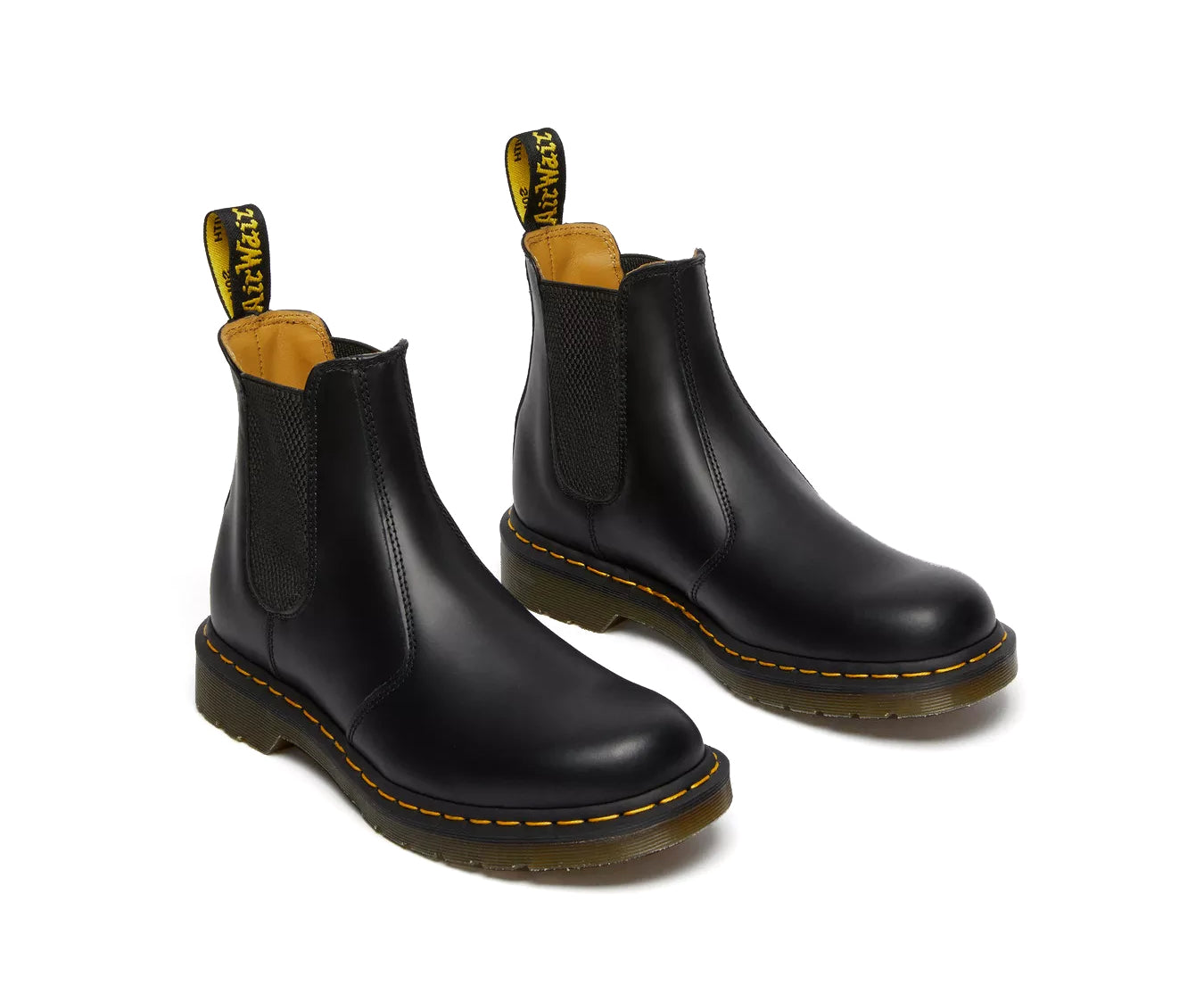 A pair of mid-ankle Dr. Martens black leather chelsea boots.