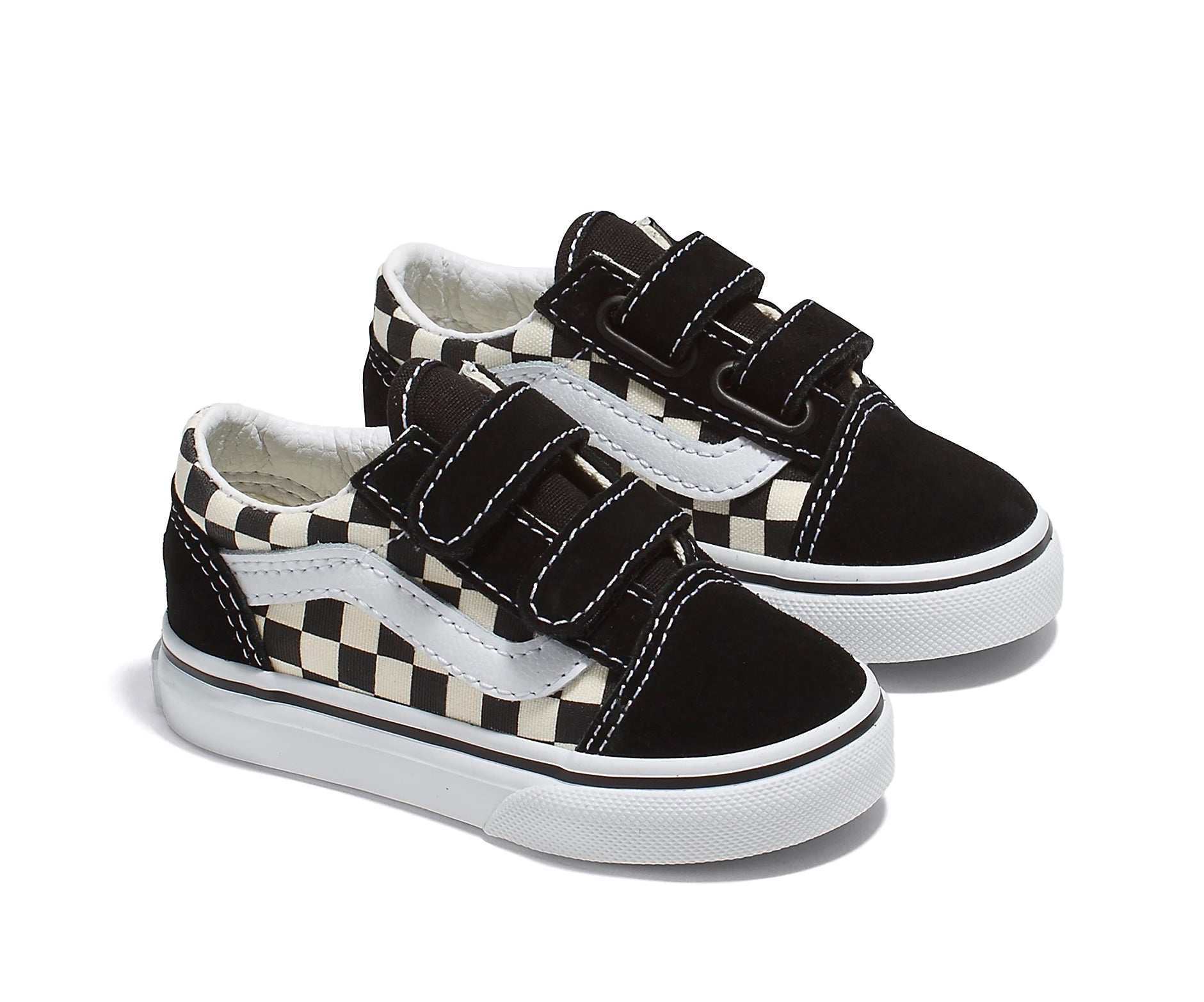 A checkerboard black and white canvas and suede kids' sneaker with velcro straps.