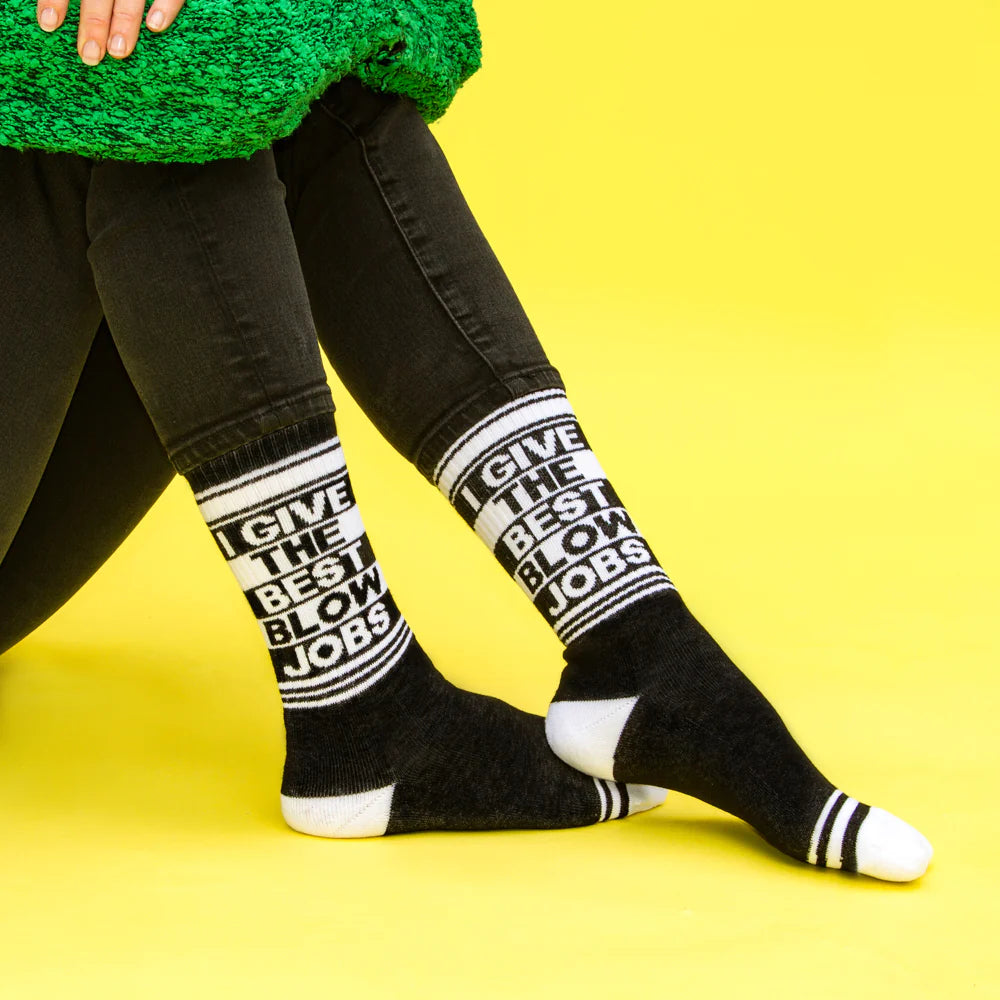 A pair of black and white crew socks that read "I give the best blow jobs."